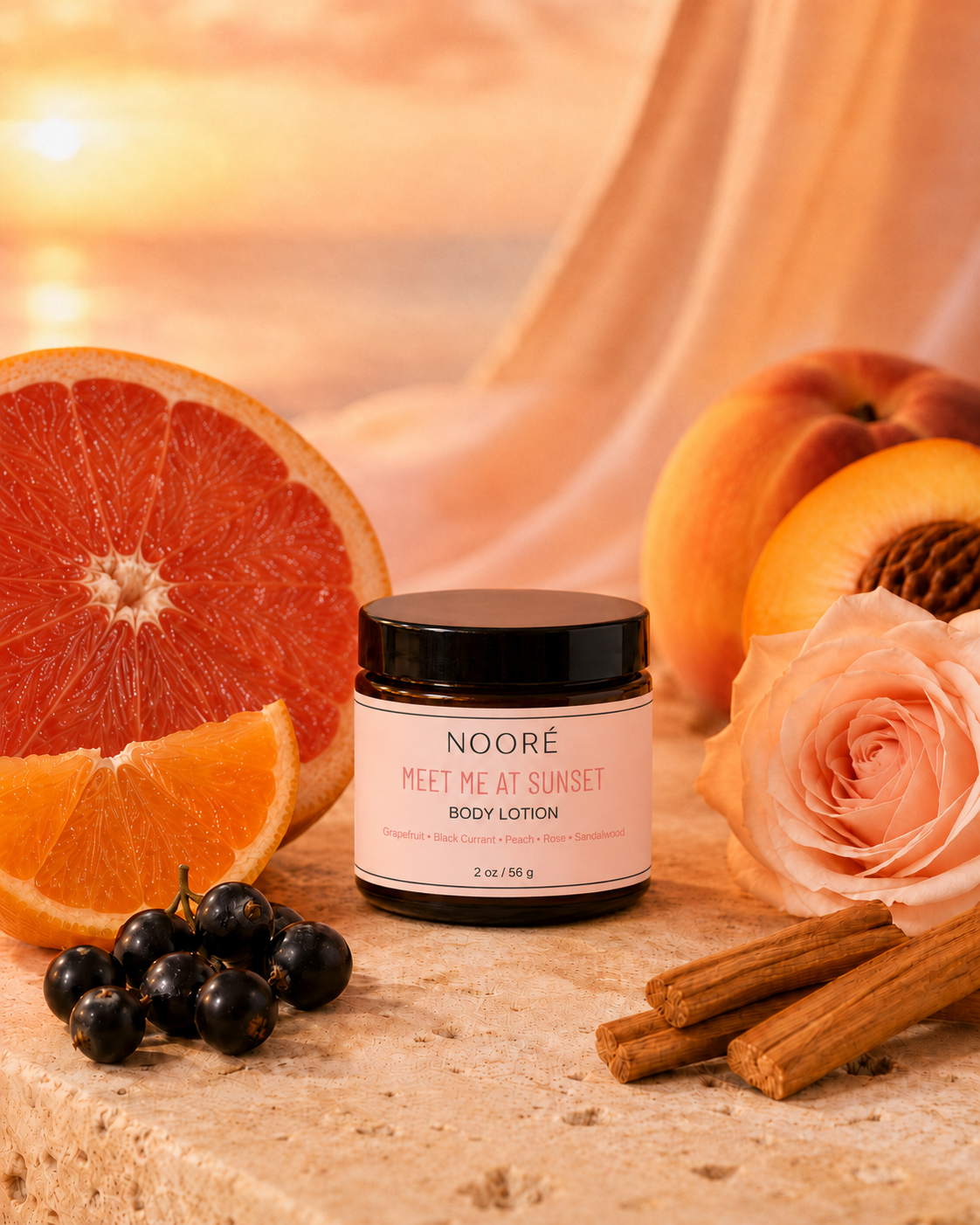 A jar of NOOR’ MEET ME AT SUNSET BODY LOTION centered on a stone surface, surrounded by citrus slices, peaches, a peach rose, blackcurrants, and cinnamon sticks against a warm draped fabric background.